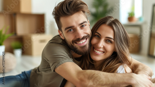 Happy couple embracing in new home with moving boxes photo