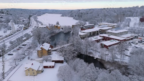 Aerial shot of the small typical Swedish village of Floda during winter with its frozen lake, dam and hydroelectric power station photo
