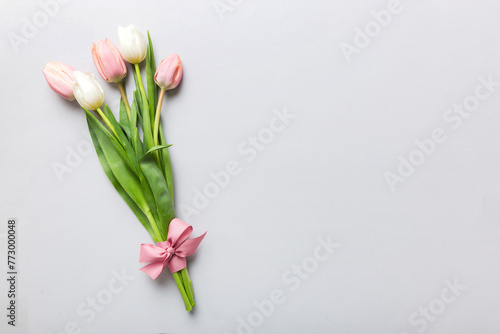 Bouquet of pink tulips on colored table background . Top view with copy space. Waiting for spring. Happy Easter card. Flat lay © sosiukin