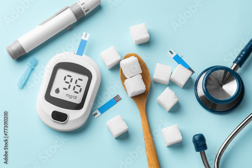 Cuadro en lienzo Diabetes concept with blood glucose meter, lancet and sugar cubes in spoon on bl