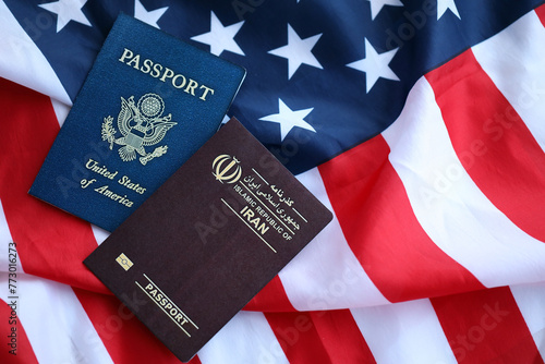 Passport of Iran Republic with US Passport on United States of America folded flag close up