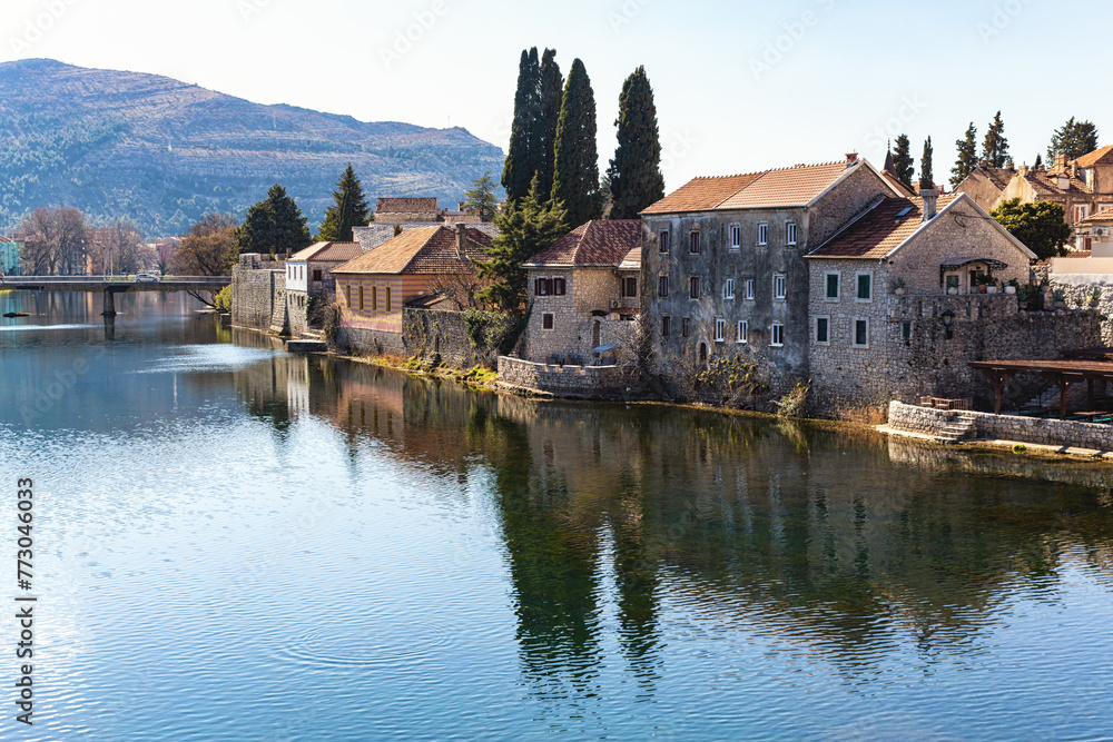 Serene river scene in Trebinje, Bosnia with historic buildings and greenery. Travel and vacation concept