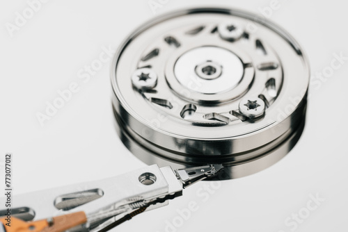 Hard drive isolated on white background. HDD. Major components of a 3.5-inch SATA hard disk drive: platter, spindle, actuator, actuator arm. Disk head above the plates	