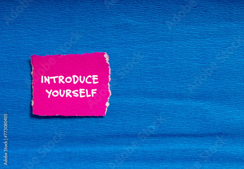 Introduce yourself words written on pink torn paper with blue background. Conceptual symbol. Copy space.