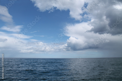 Blue Sky and White Clouds Over an Open Ocean Sea.