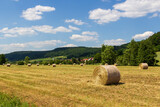 Rural scene with round hay bales and hill panorama near village Wannbach in Franconian Switzerland, Germany