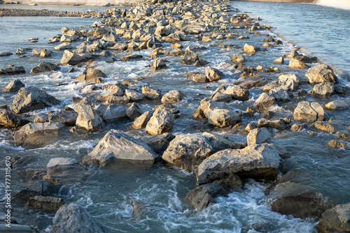 A rocky shoreline with a body of water in the background
