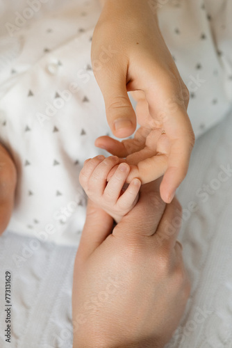 Close up of hand holding babys tiny, soft fingers