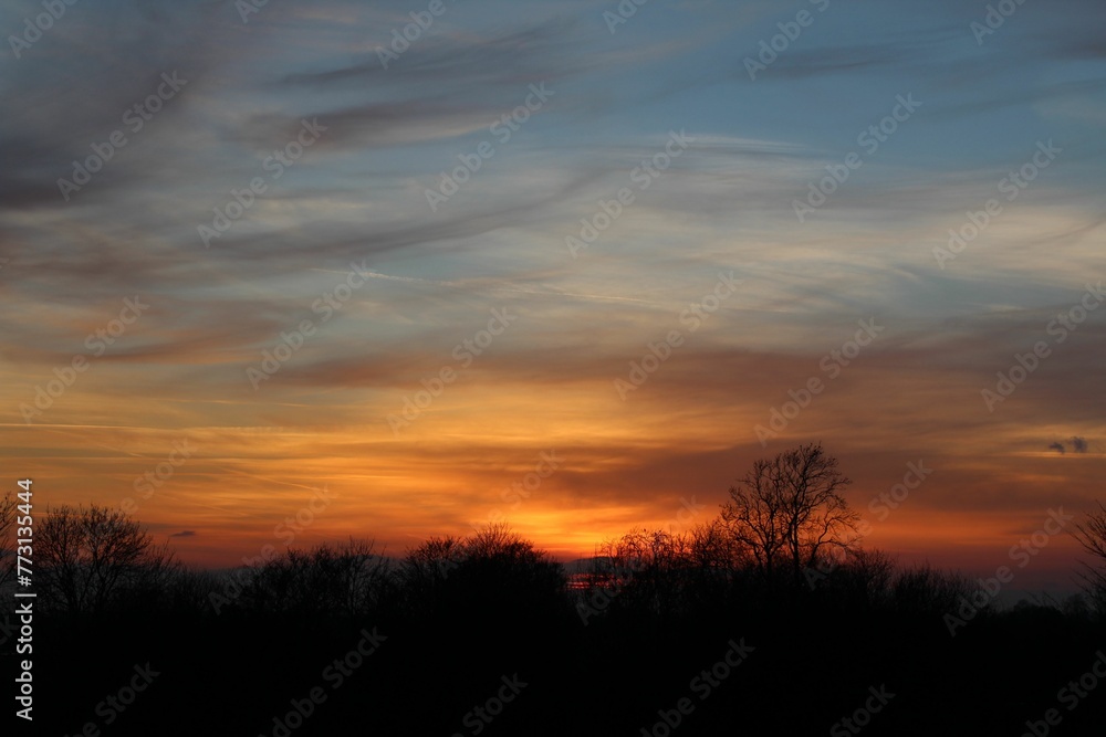 Orange sunset from a hilltop with clouds in the background