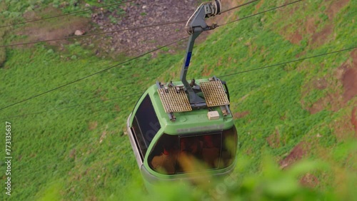 A funicular on the island of Madeira takes people down from a high cliff with an incredible view from above to the ocean and a small picturesque village Achadas da Cruz photo