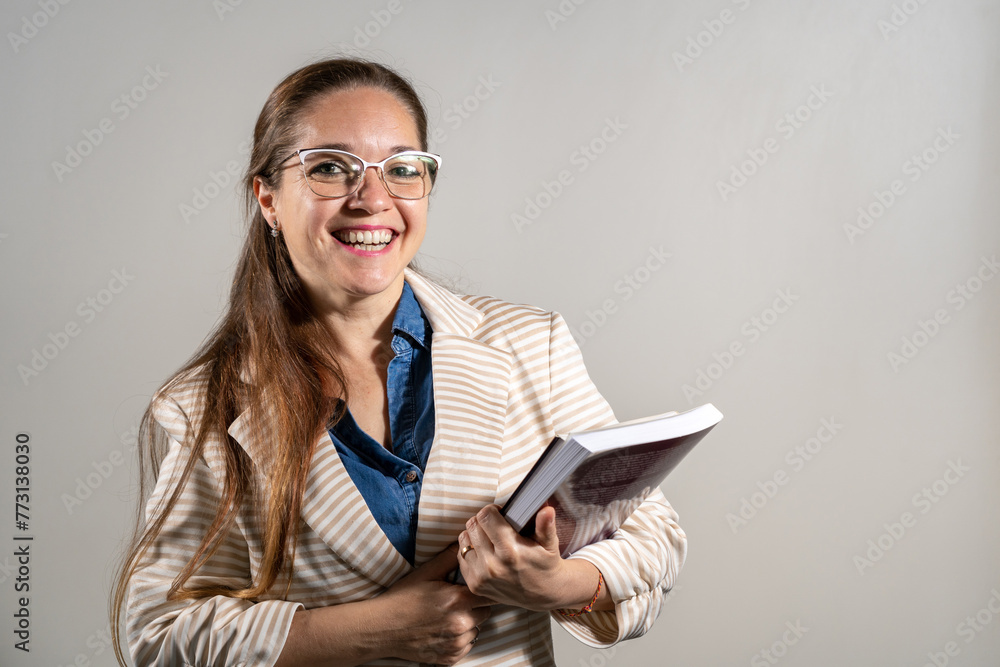 Mujer estudiante sosteniendo sus notas y libros mientras sonrie a cámara. Mujer estudiante sosteniendo sus notas y libros mientras sonrie a cámara.