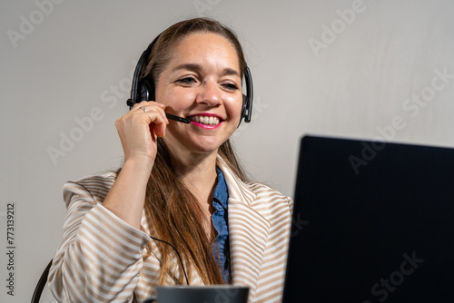 Mujer en una tele llamada, sonriente y mirando a cámara. Concepto de mesa de ayuda y asistencia virtual	 photo