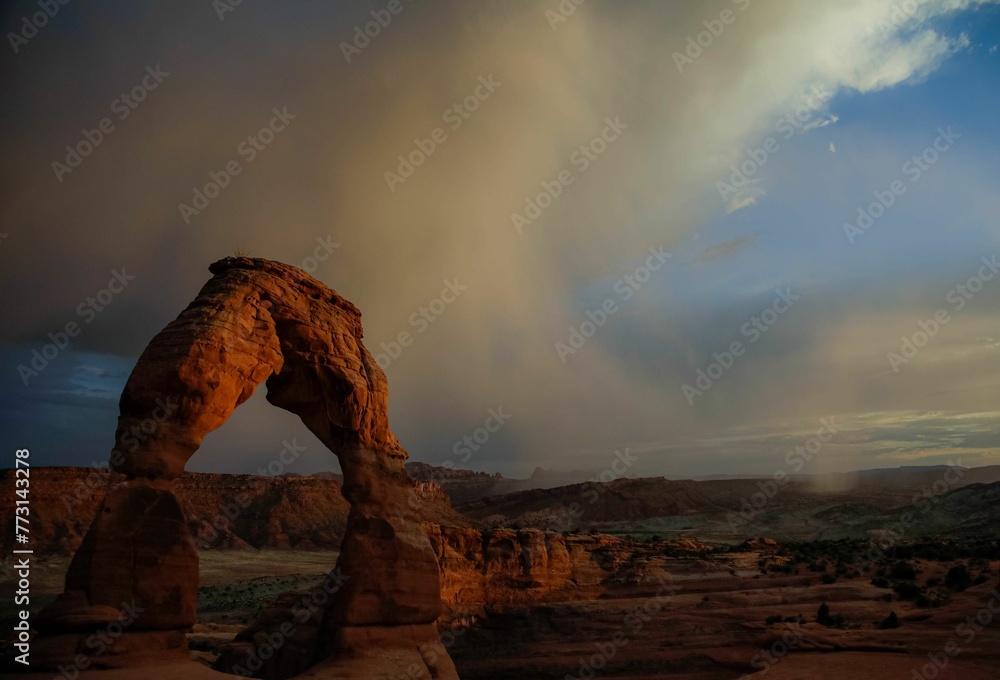 Scenic view of Delicate Arch in Grand County, Utah at a cloudy sunset