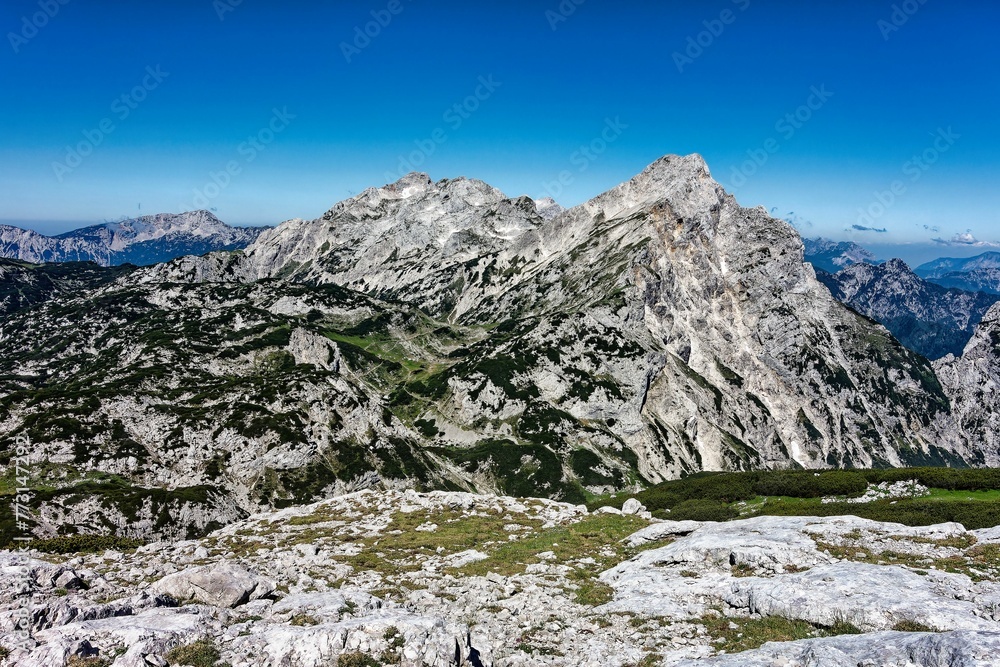 Scenic view of a valley with lush green fields below and surrounding hills in the background