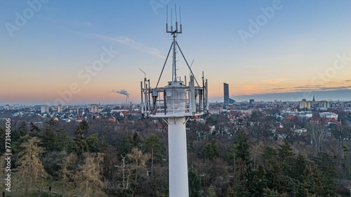 Aerial view of a large antenna tower over a park at sunset in Wroclaw, Poland