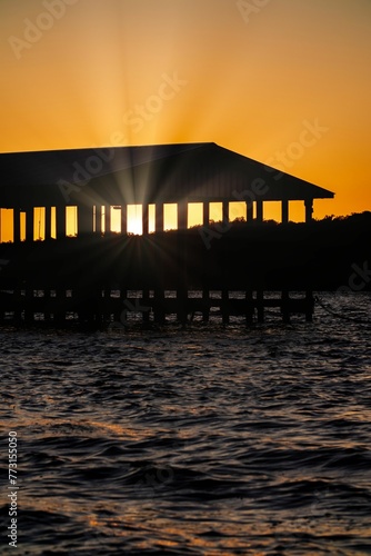 a wooden dock with a dock house on it during the sunset