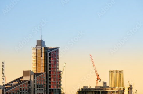 Modern buildings and a contruction crane against the beautiful sunset sky
