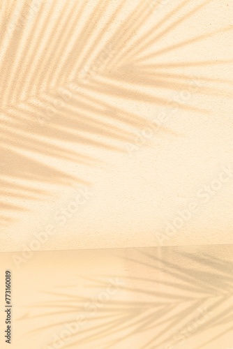 Palm leaf shadow on Abstract cream pastel studio background for product presentation. Vertical empty room with shadow of tropical palm leaves. Creative mockup, minimal summer concept
