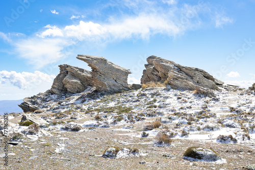 Formaciones rocosas en la cima de una montaña nevada con el cielo azul. Calar Alto, Almería. photo