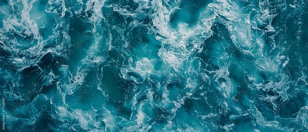   A large body of water with blue-and-white crested waves from above