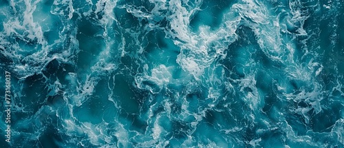  A large body of water with blue-and-white crested waves from above