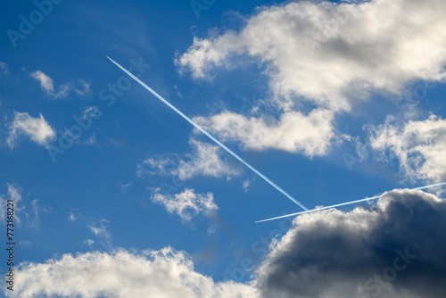 Deux avions jets dont les traces blanches se croisent dans le ciel