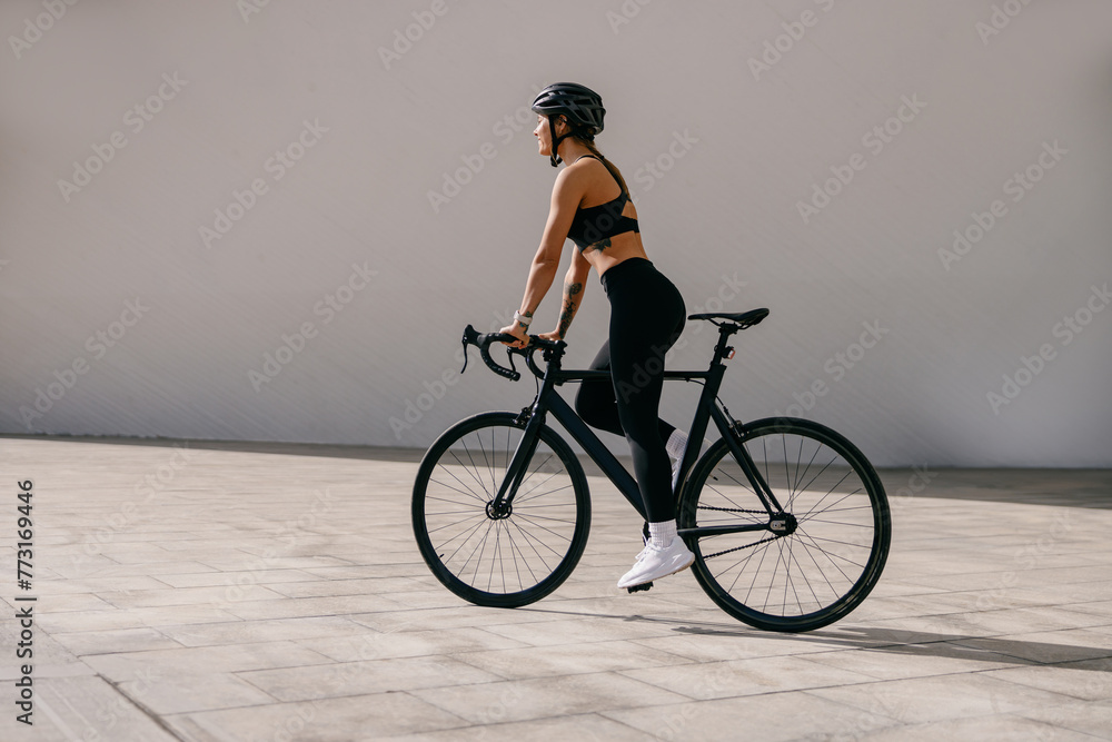 Side view of sporty young woman with bicycle do sports activity. Healthy lifestyle concept Side view of sporty young woman with bicycle do sports activity. Healthy lifestyle concept
