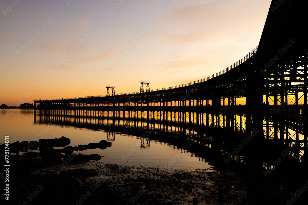 Fototapeta premium Captivating sunset scenery unfolds at The Rio Tinto Pier (Muelle de Rio Tinto) in Huelva, Andalusia, Spain
