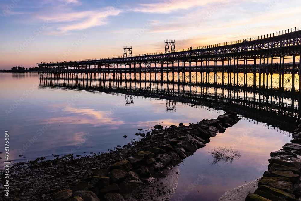 Captivating sunset scenery unfolds at The Rio Tinto Pier (Muelle de Rio Tinto) in Huelva, Andalusia, Spain Captivating sunset scenery unfolds at The Rio Tinto Pier (Muelle de Rio Tinto) in Huelva, Andalusia, Spain