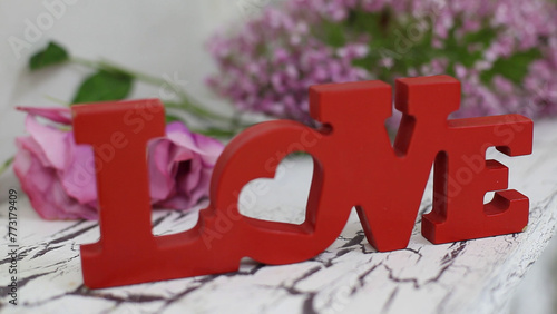 word love on an old wooden background with a bouquet of flowers