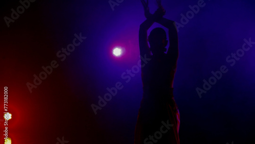 silhouette of a woman dancing on the stage in the dark