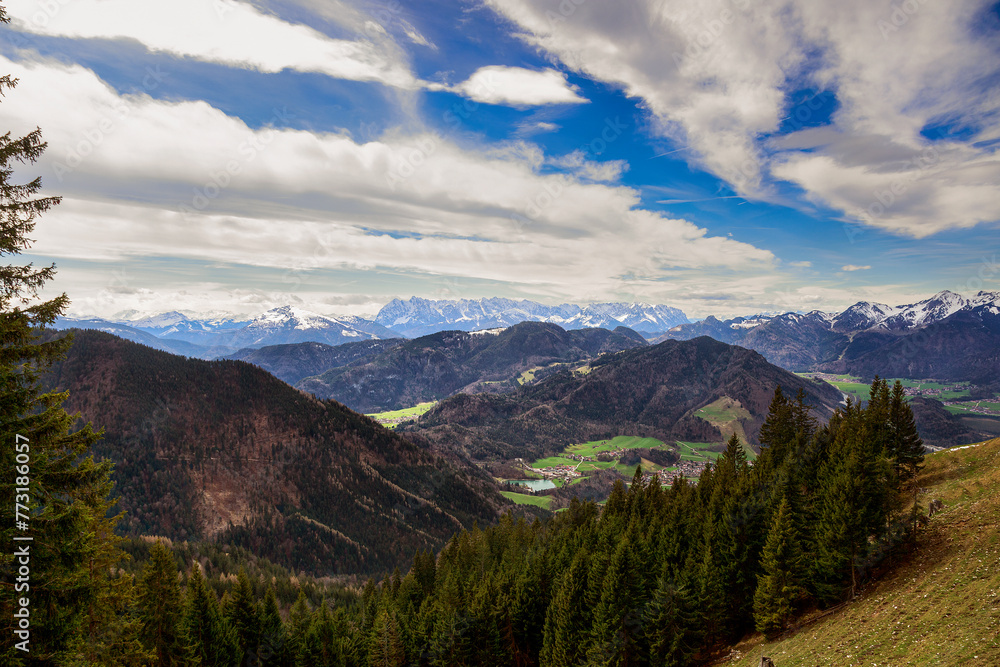 Panoramablick auf die schneebedeckte Chiemgauer Berge und grüne Hügel oberhalb vom Dorf Unterwössen in den Chiemgauer Alpen Bayern Deutschland
