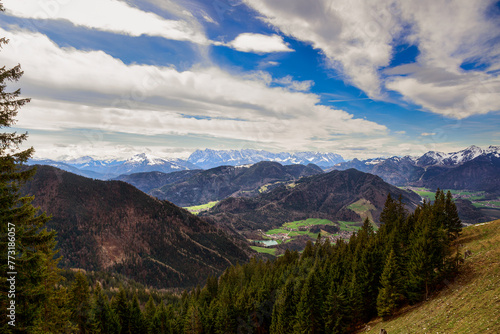 Panoramablick auf die schneebedeckte Chiemgauer Berge und grüne Hügel oberhalb vom Dorf Unterwössen in den Chiemgauer Alpen Bayern Deutschland