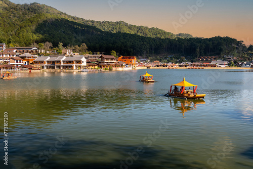 Beautiful landscape Tourists sit on a boat in the lake at Ban Rak Thai, Unseen Thailand At Ban Rak Thai, Mae Hong Son Province photo