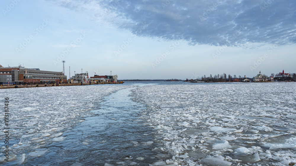 ferry service to suomenlinna island to Helsinki harbor during winter with ice in the bay. Docks on the left side make this trip a perfect sightseeing boat tour.