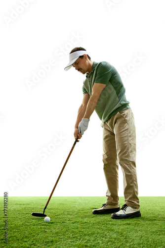 Focused, skilled golf player in casual attire at start of powerful drive with golf club against white studio background. Concept of professional sport, luxury games, active lifestyle, action. Ad