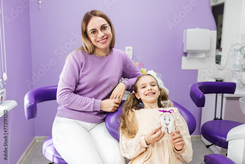 Smiling dentist and patient looking at camera portrait. Well-equipped dental clinic office. Stomatology, dentistry, orthodontology. X-ray image on computer monitor screen. Consultation and app