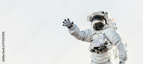 An astronaut reaching out towards the viewer against a clear sky backdrop, symbolizing connection and exploration