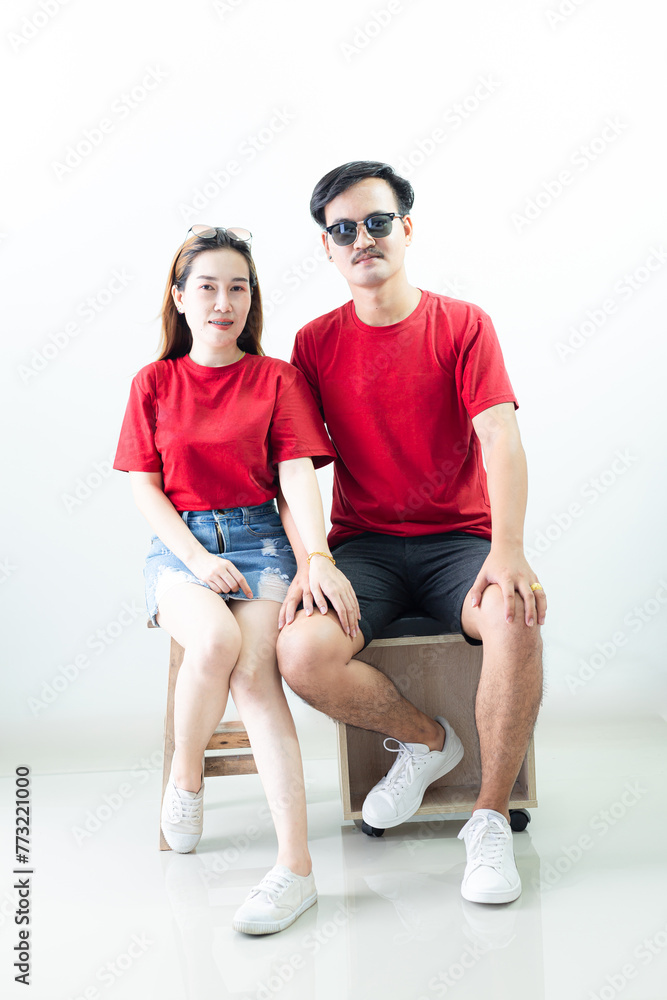 Obraz premium Young Asian couple isolated on white background,Young attractive Asian couple wearing red t shirt and white shorts standing together, woman holding bouquet of flower against white background. Concept 