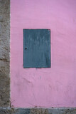Small blue metallic door on a Pink Wall