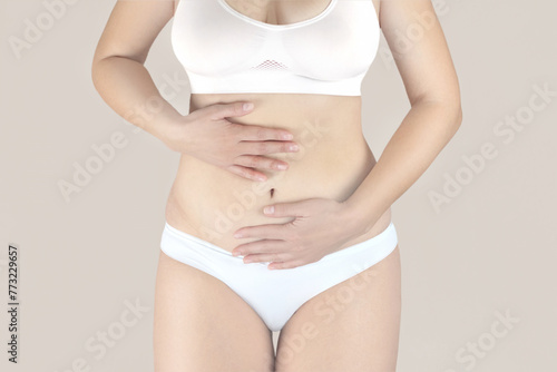 Fotografie Woman in white underwear with menstrual pain is holding her aching belly, woman