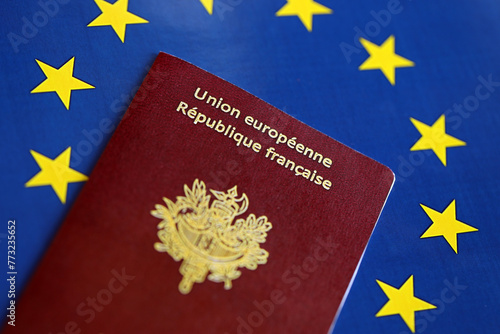 French passport of European Union on blue flag background close up. Tourism and citizenship concept