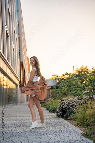 Attractive young woman enjoying her free time at sunset outdoor. Happy girl portrait at summer. Freedom lifestyle summer concept. Sun glow on background.