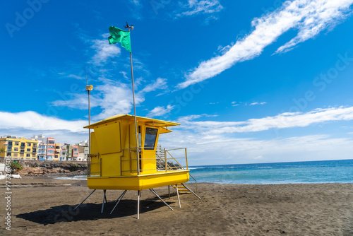 Yellow lifeguard tower in California with green flag in summer by the sea © unai
