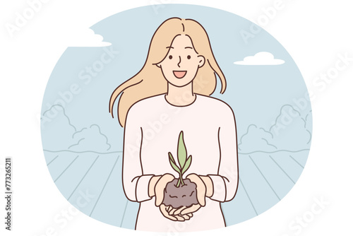Woman demonstrates handful of soil with young plant for concept of caring for nature