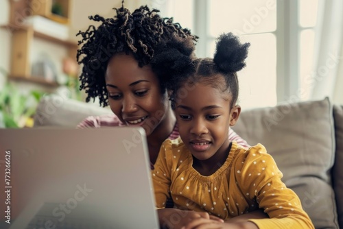 Mother and daughter sharing a fun educational moment with a laptop.