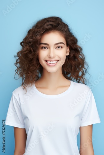 Beautiful young woman in white empty t-shirt on blue background. Mockup