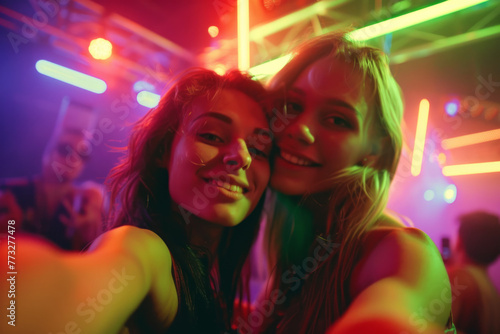 Friends capturing selfies against the vibrant backdrop of nightclub illumination