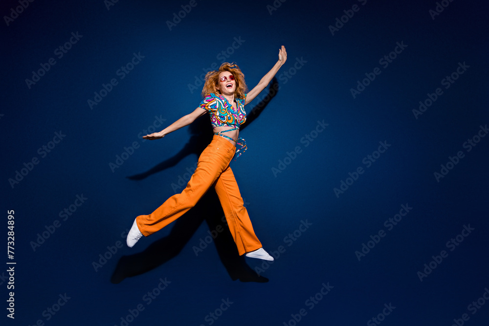 Full body profile portrait of nice young lady jump empty space wear top isolated on dark blue color background