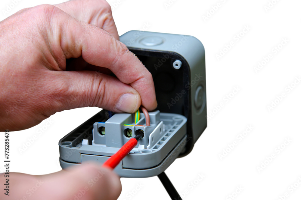 Man wiring an outdoor electric socket using an electrical screwdriver. Isolated on a white background Man wiring an outdoor electric socket using an electrical screwdriver. Isolated on a white background